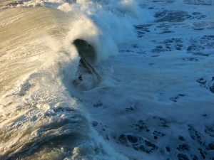 Surfer in wave at Oceanside Beach, CA