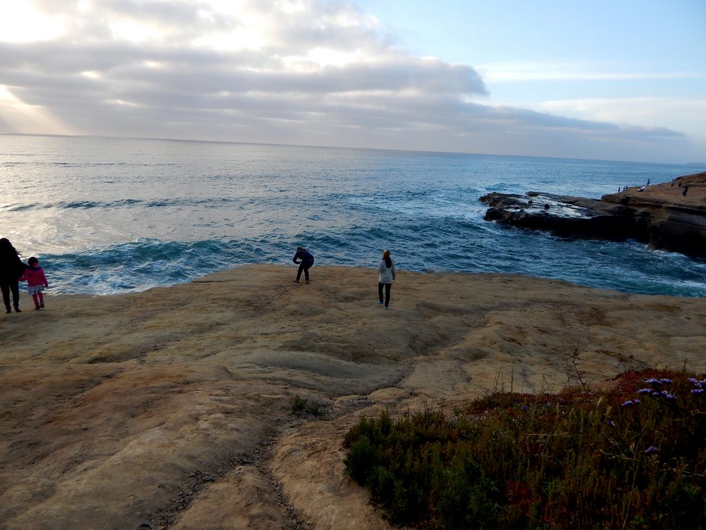 four people bluff overlooking Ocean Sunset Cliffs Natural Park