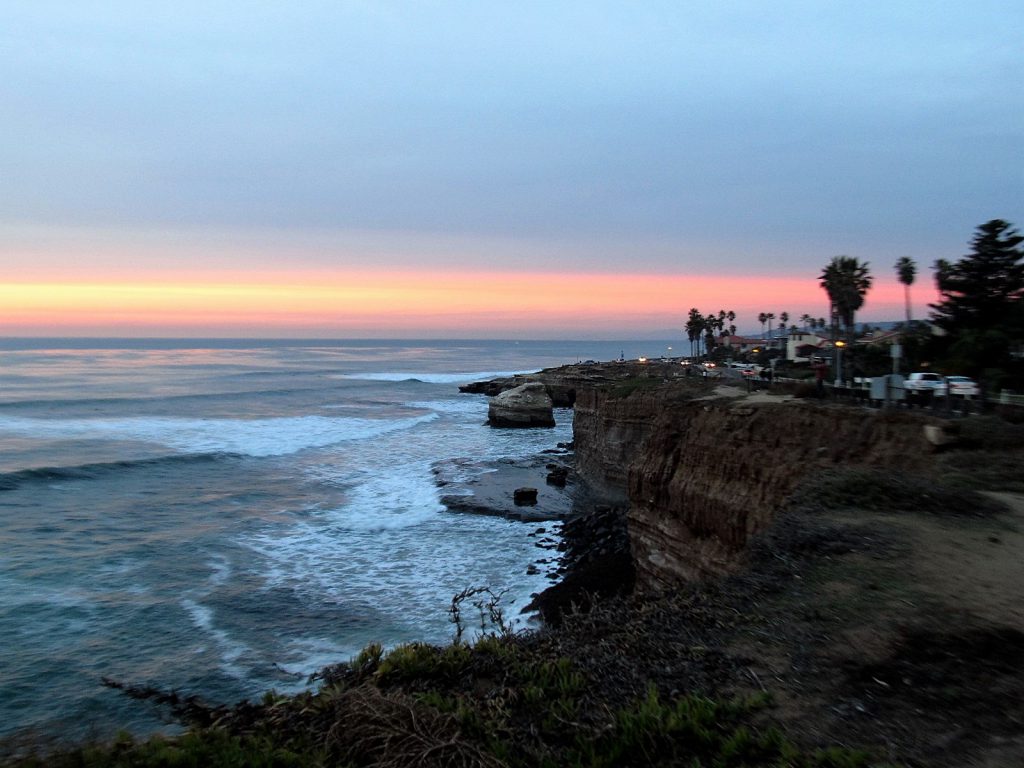 Sunset over water on edge of bluff