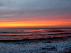 Deep red sunset waves foamy water