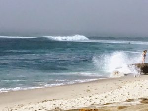 Wave crashing woman rock La Jolla Strand Beach